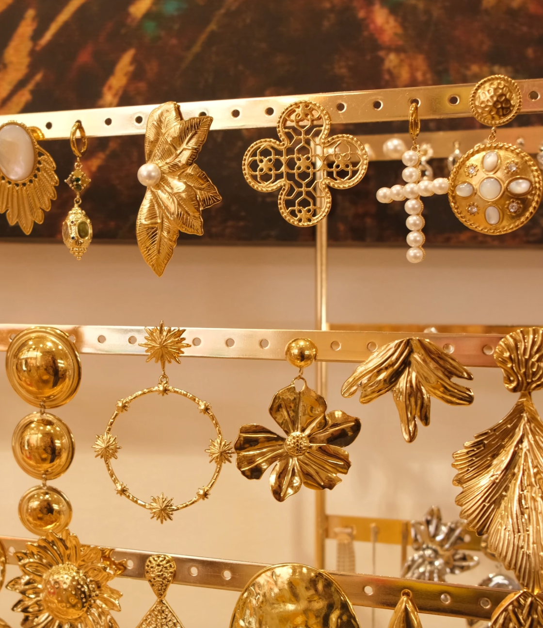 Gros plan sur des boucles d’oreilles dorées avec motifs floraux et perles, disponible dans la boutique Boudoir de Lily au Mans.